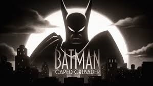 Title card of Batman: Caped Crusader, featuring a menacing man in a sharp-eared bat mask and cloak looming over a cityscape, with a full moon and clouds behind him.